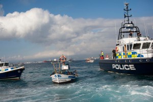 British patrol boats, left and right, block access as a fisherman on his fishing boat, center, protests near to La Linea de la Concepcion in front of Gibraltar, Spain, Sunday, Aug. 18, 2013