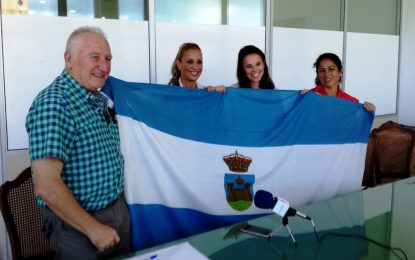Helenio Lucas Fernández  entrega la bandera de la ciudad a las tres deportistas que participarán en la Media Maratón de Lisboa